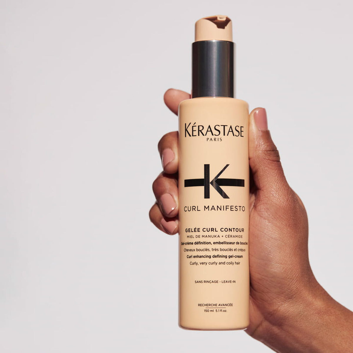 Kerastase Curl Manifesto gel-cream bottle held in hand, pump dispenser